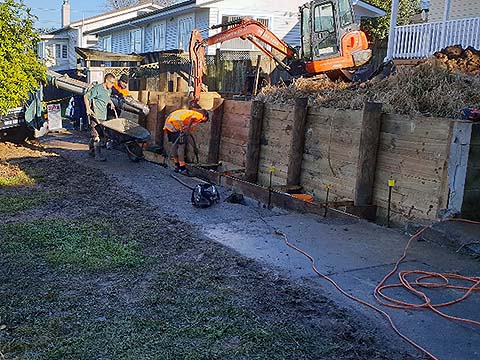 Concreting area in front of new timber retaining wall in Onehunga